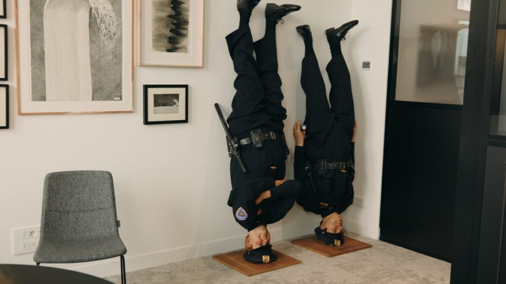 Frank and Jamie (2002), œuvre de Maurizio Cattelan représentant deux policiers new-yorkais installés la tête en bas contre un mur dans les bureaux de HB & Associés avec Gilles Hittinger-Roux